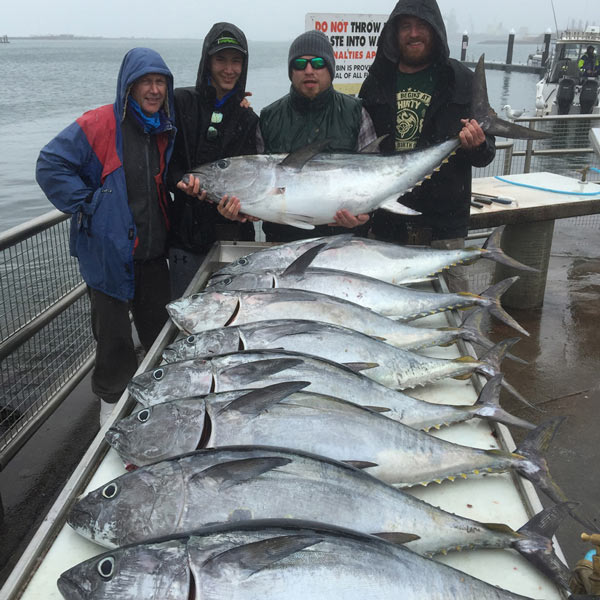 four happy bagout tuna fishing charter customers with caught fish