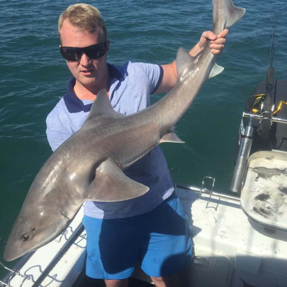 man holding gummy shark bag out fishing charters